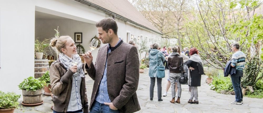 Ein Paar geniesst im Weinfrühling in einem Weingut ein Achtel Wein